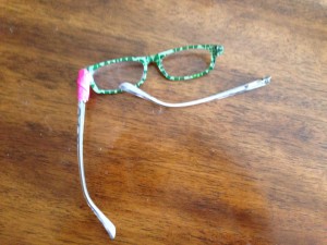 Glasses horribly bent, one arm off and one fixed with bright pink duct tape